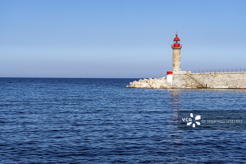 巴斯蒂亚港口的灯塔，前方是深蓝色的海洋，科西嘉岛，法国，欧洲图片素材