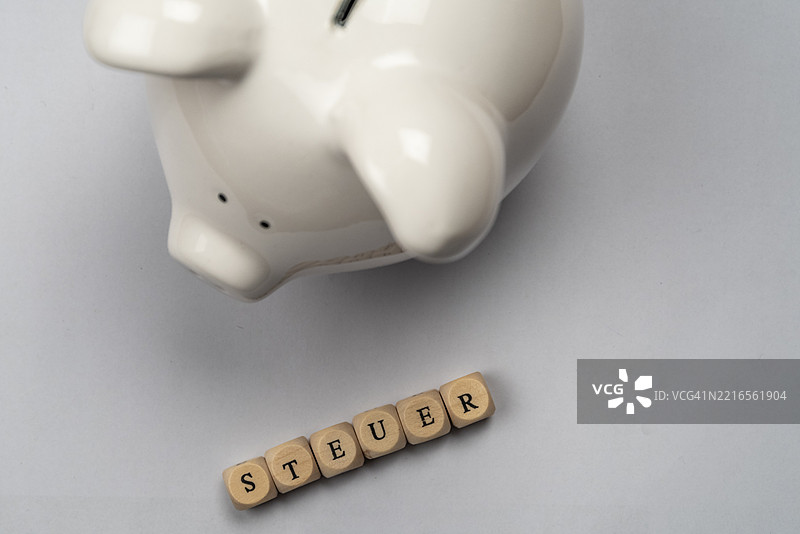 白色储蓄罐和税务字母在白色背景下，俯视图，摄影棚拍摄，德国，欧洲图片素材