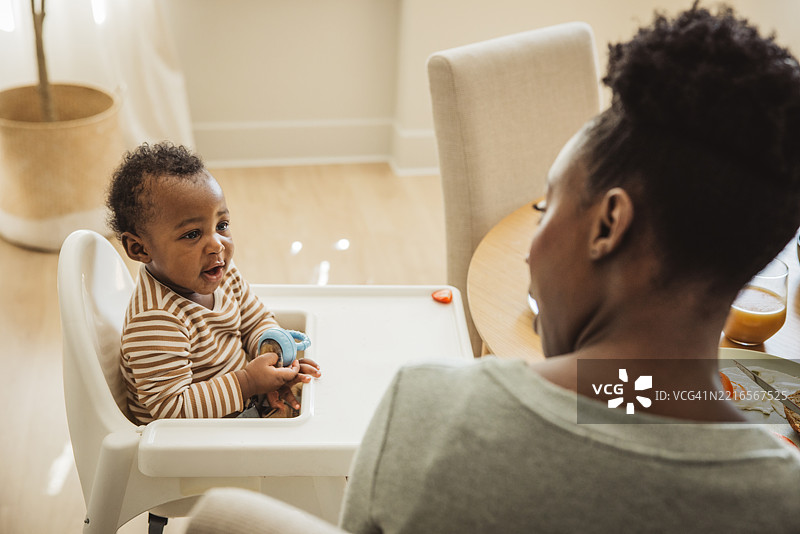 母亲与婴儿儿子一起吃早餐图片素材