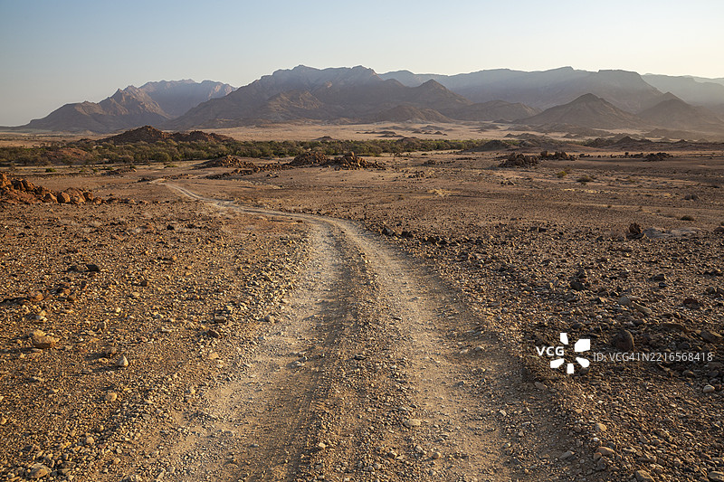 通往乌加布河干涸河床的碎石路,位于纳米比亚最高峰布兰登堡山后方,达马拉兰,纳米比亚,非洲图片素材