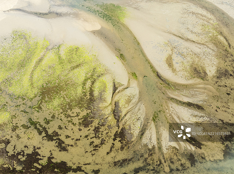 在西班牙安达卢西亚省乌埃尔瓦的伊斯拉克里斯蒂娜,海鸥湖的低潮时沙质沉积物、河道和溪流的鸟瞰图。无人机拍摄。图片素材