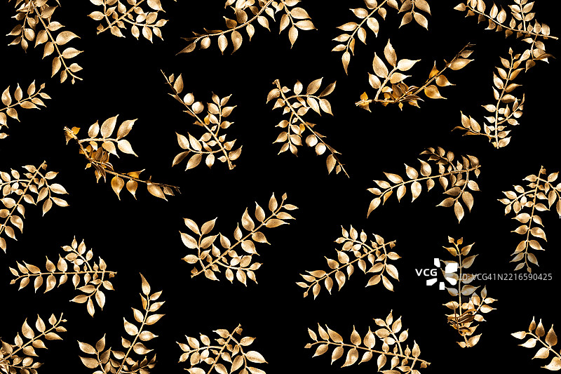 黑色背景上的金色叶子纹理。作为抽象背景。图片素材
