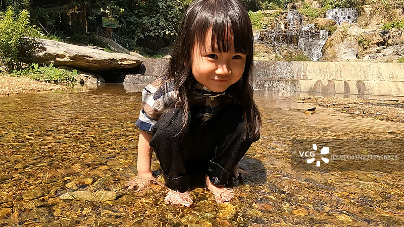 一家人在瀑布旁享受乐趣。图片素材