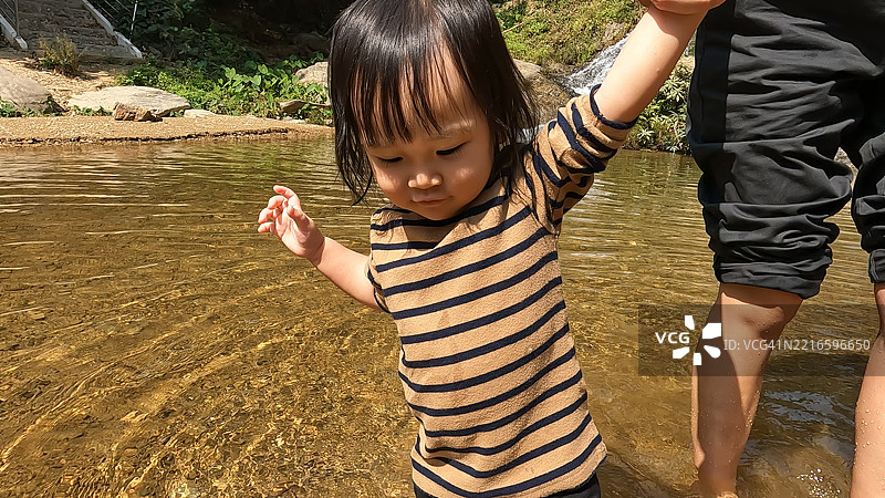 一家人在瀑布旁享受乐趣。图片素材