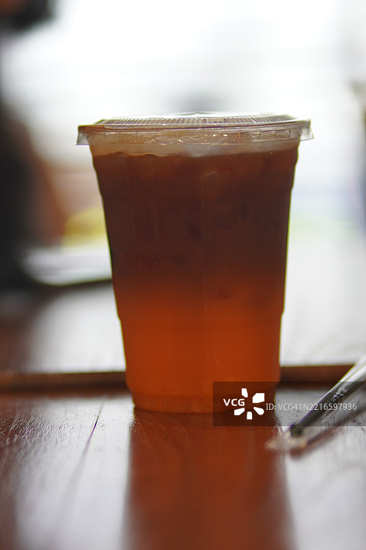 冰柚子咖啡放在木桌上，背景模糊，饮品图片素材