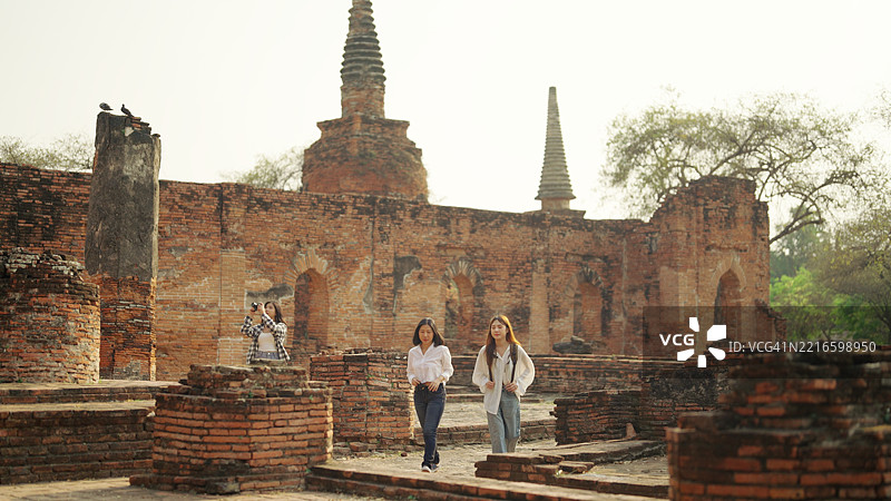 一群亚洲背包女游客参观寺庙。图片素材