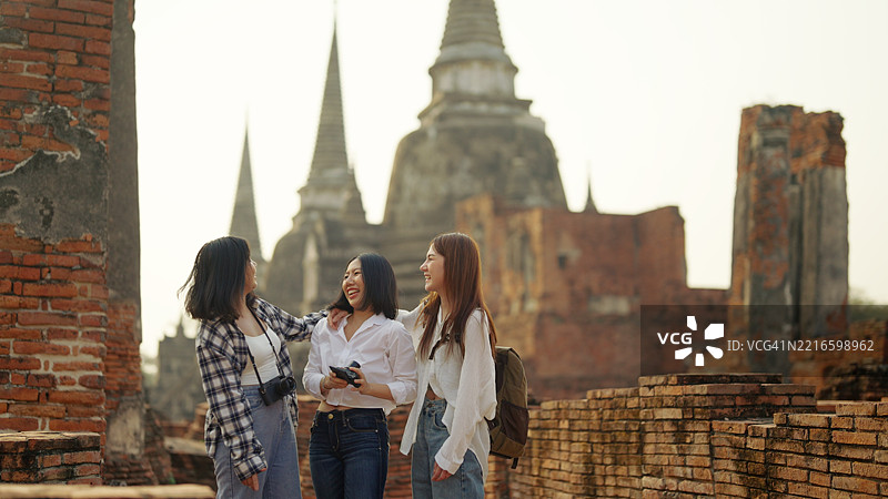一群亚洲背包女游客参观寺庙。图片素材