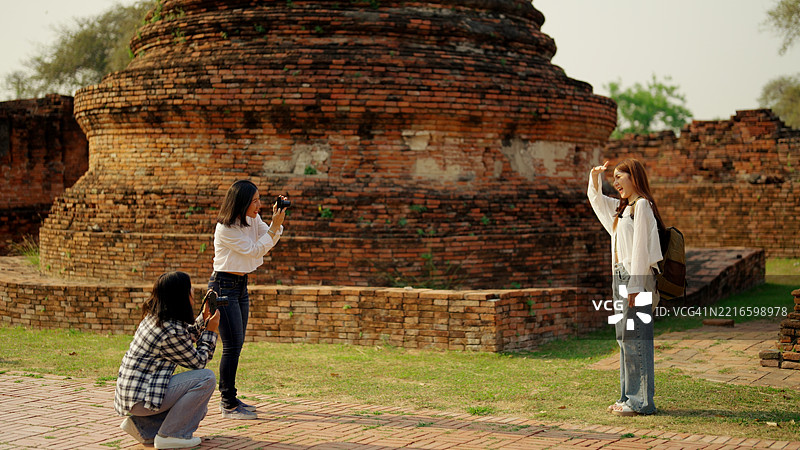 一群亚洲背包女游客参观寺庙。图片素材