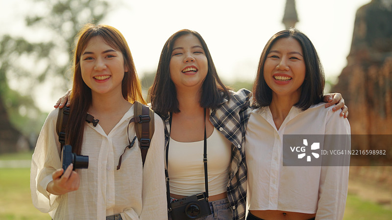 一群亚洲背包女游客参观寺庙。图片素材