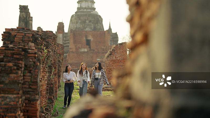 一群亚洲背包女游客参观寺庙。图片素材