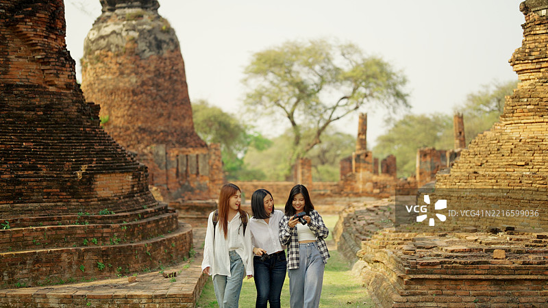 一群亚洲背包女游客参观寺庙。图片素材