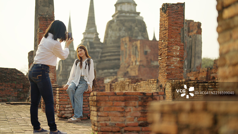 一群亚洲背包女游客参观寺庙。图片素材
