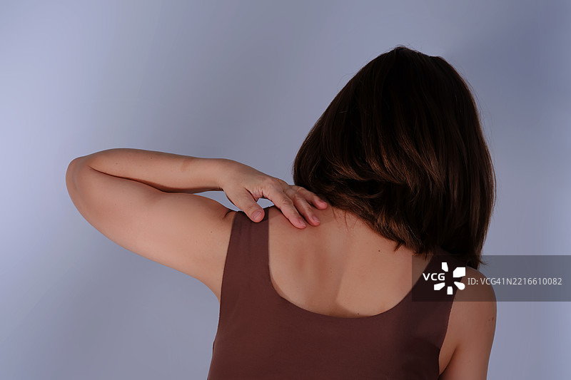 一名女性感到斜方肌疼痛。图片素材