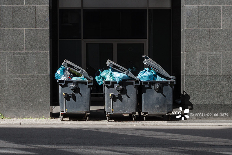 三个大型黑色垃圾桶。图片素材