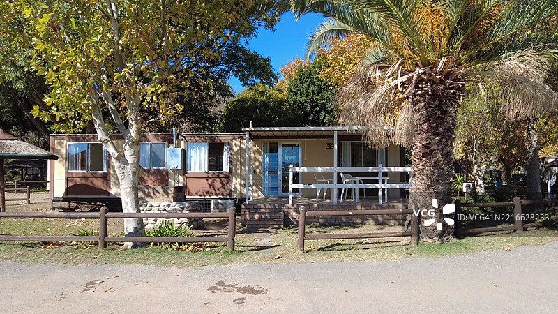 维护良好的制造房屋，四周环绕着郁郁葱葱的绿意和户外风景图片素材