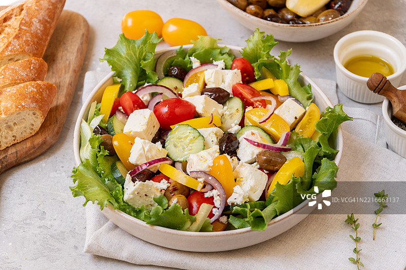 希腊沙拉，配有羊奶酪、新鲜番茄、罗勒、洋葱、橄榄和橄榄油，健康食品。图片素材