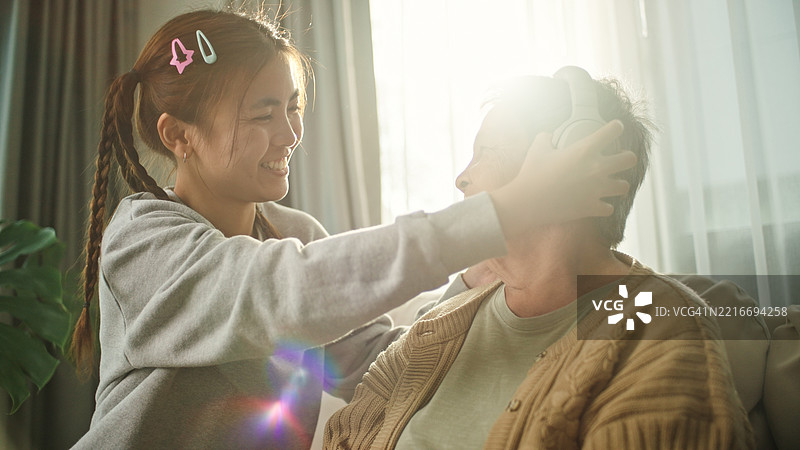 老年女性与年轻人一起放松地倾听。图片素材