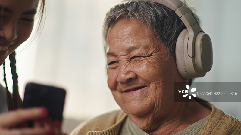 老年女性与年轻人一起放松地倾听。图片素材