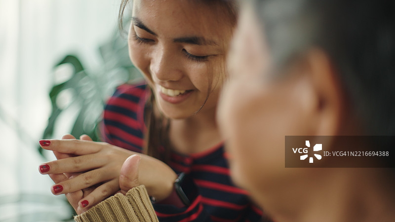 青少年与老人放松交谈，展示指甲时尚。图片素材