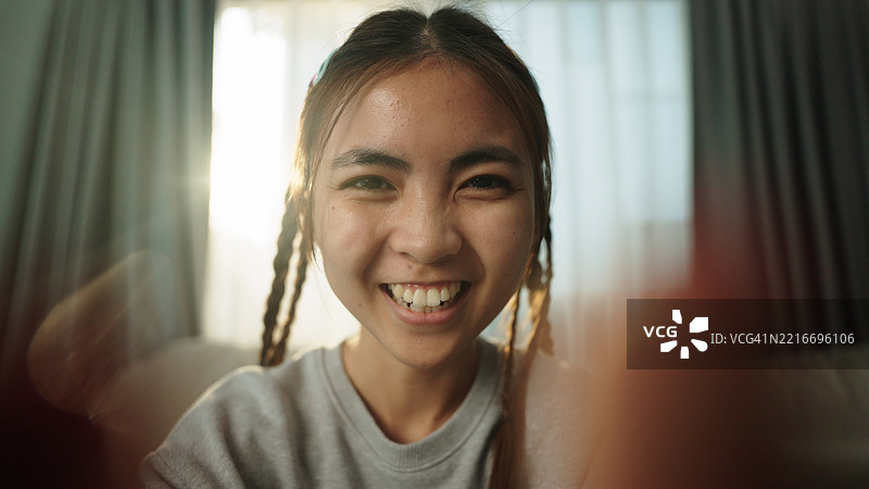 视角：一位亚洲少女正在使用智能手机。图片素材