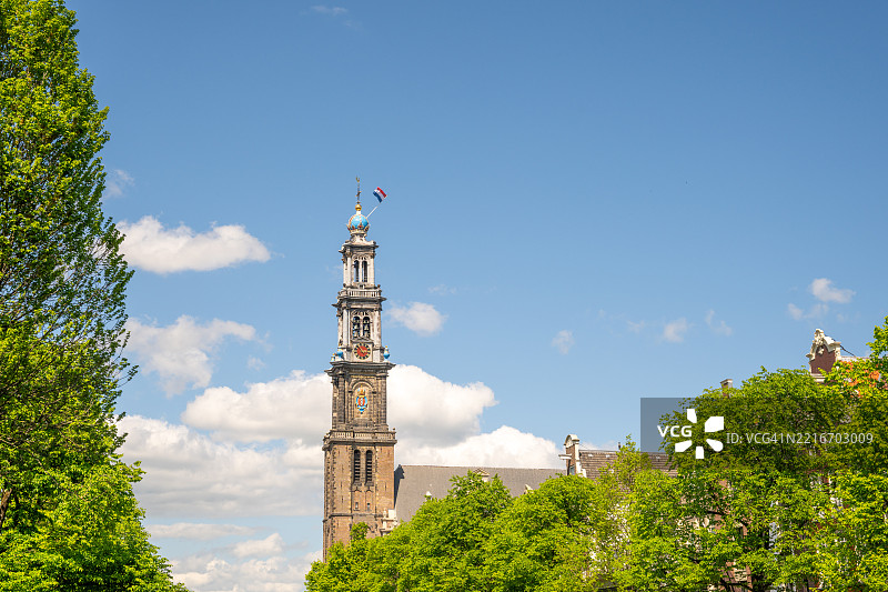 西教堂钟楼高耸于绿树之上图片素材