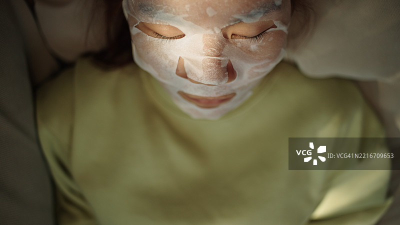 青少年放松时使用面膜。图片素材