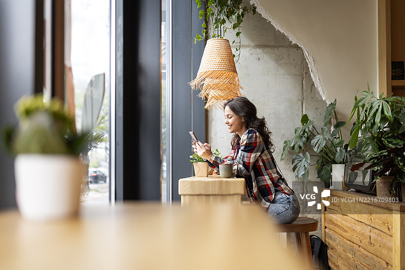 手拿咖啡和智能手机的女性图片素材