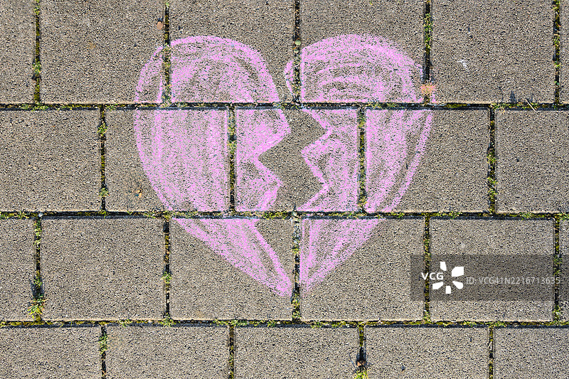人行道上的破碎心形粉笔画图片素材