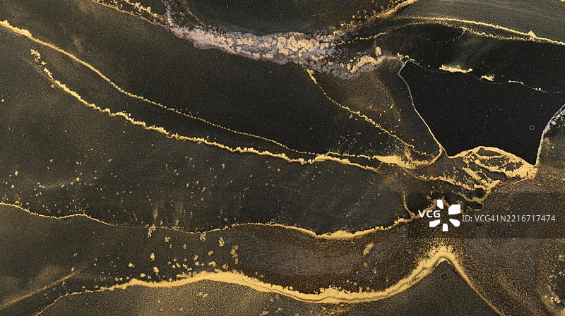 美丽的抽象酒精墨水设计，呈现丰富的黑色和金色。图片素材