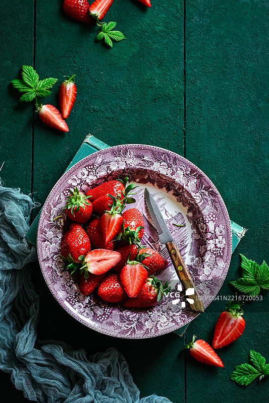 高角度视图的草莓放在桌子上的盘子里图片素材