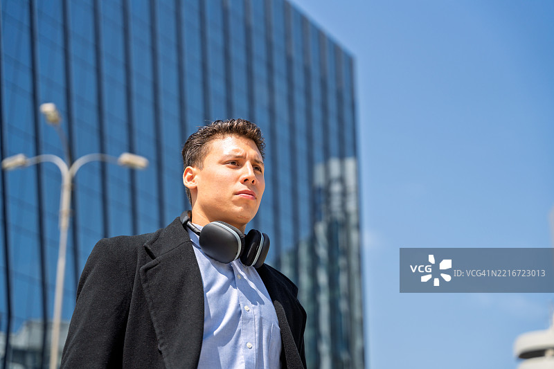 商人在金融区戴着耳机走路图片素材