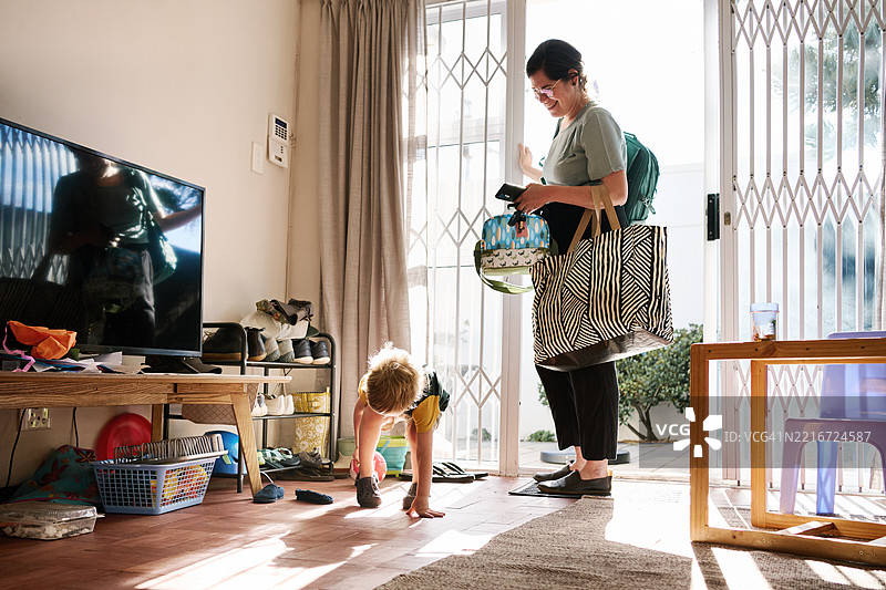母亲准备带着儿子离家，地上放着鞋子图片素材