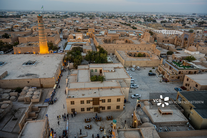 高处黄昏时分的希瓦古城景观，伊斯兰·霍贾尖塔灯光璀璨。图片素材