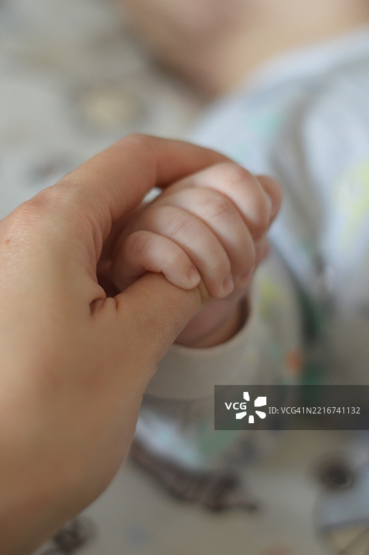 婴儿握着手指的特写镜头图片素材