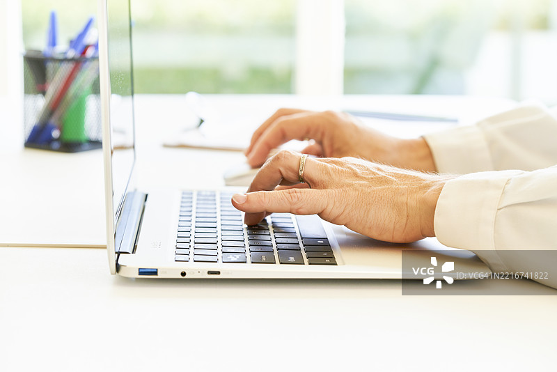 高级经理在办公室用笔记本电脑打字图片素材