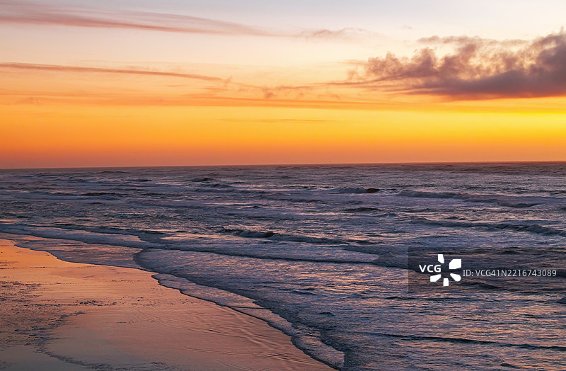 加利福尼亚州半月湾的海洋日落，创造出色彩斑斓的天空和反射的海岸线。图片素材