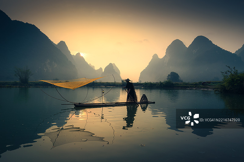 越南丰南谷日出时在木筏上的渔夫图片素材