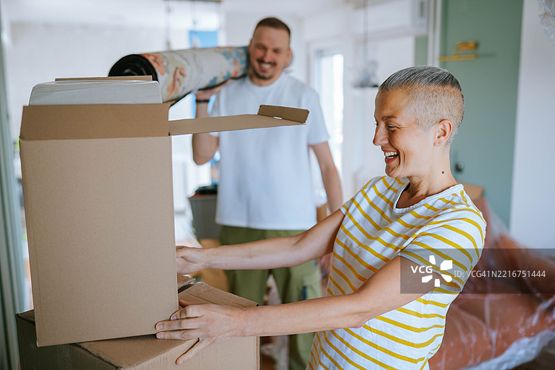 一对可爱的年轻情侣搬进新家的人像图片素材