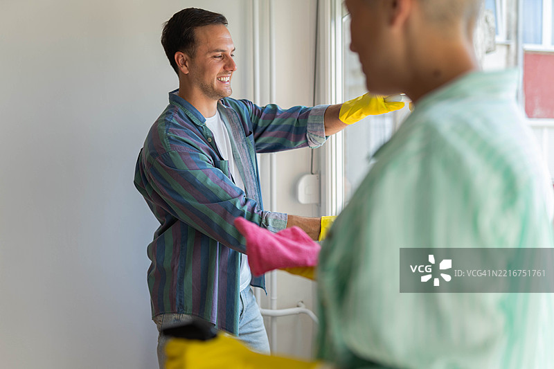 无忧无虑的情侣在一起快乐地打扫他们的新公寓图片素材