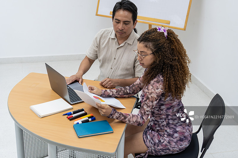 拉丁美洲同事在办公桌前审阅文件图片素材