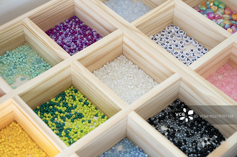 一个装有各种颜色珠子和石头的木盒子图片素材