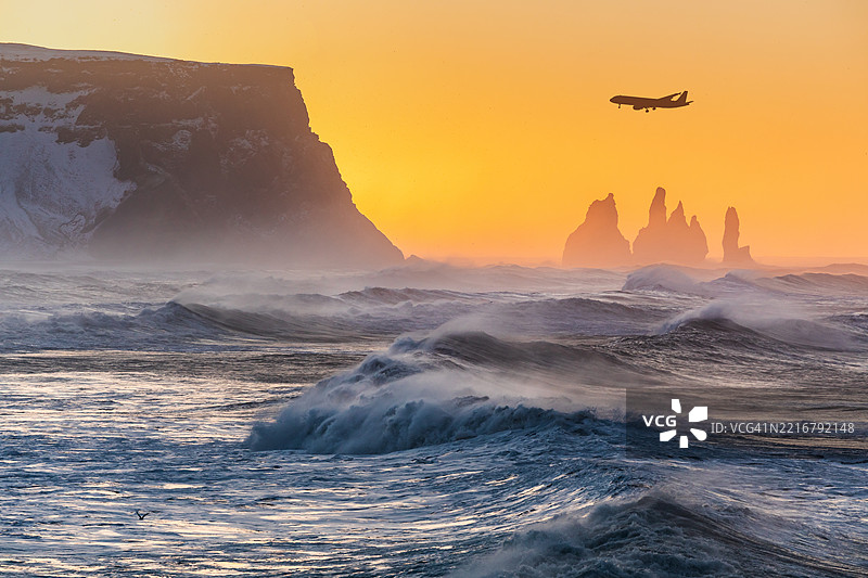日出时分，飞机飞越海景。冰岛维克。图片素材