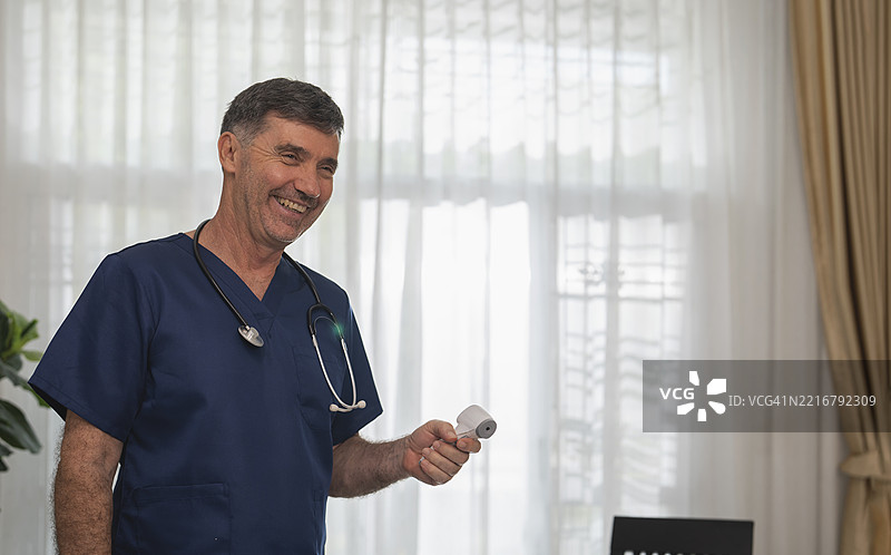 医生在家访时为老年患者测量血压图片素材