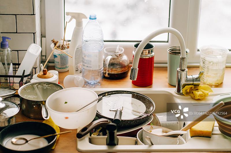 餐后脏盘子堆积在厨房水槽里图片素材
