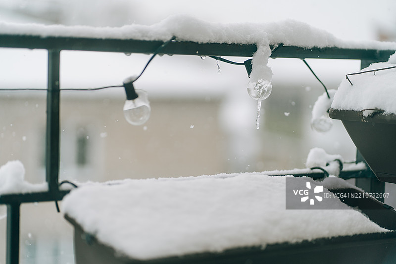 阳台栏杆上飘落的雪花，伴随着串灯和冰柱图片素材