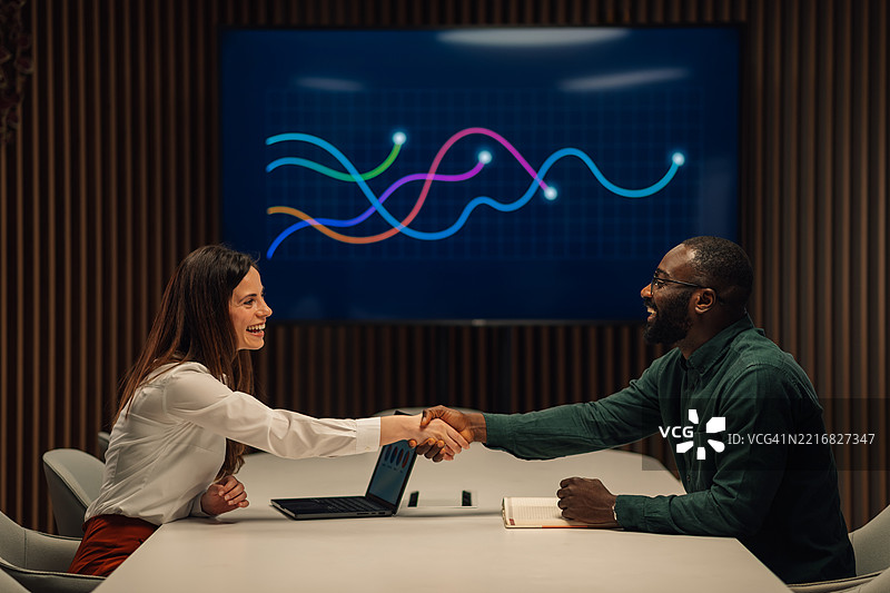 商界人士在成功展示积极商业成果后握手。图片素材