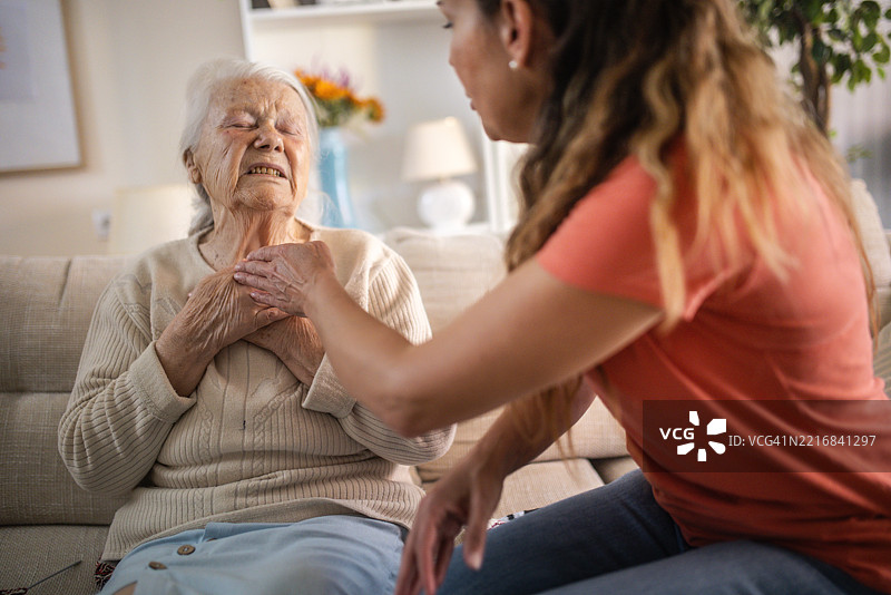 女儿在母亲心脏病发作时帮助她并拨打了救护车。图片素材