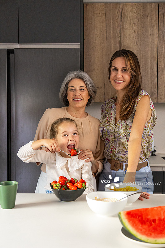 三代女性在现代厨房里一起享用健康早餐图片素材