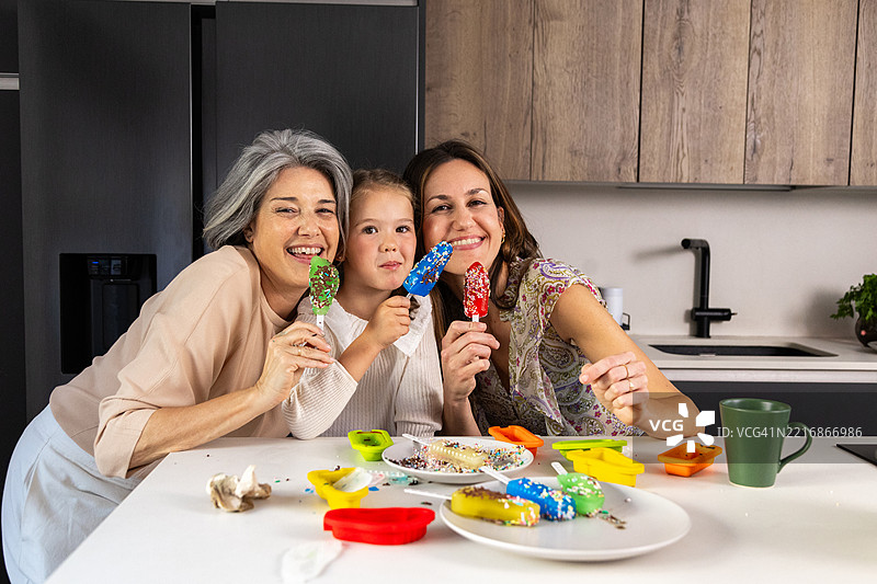 快乐的家庭在厨房里享用自制冰淇淋棒图片素材