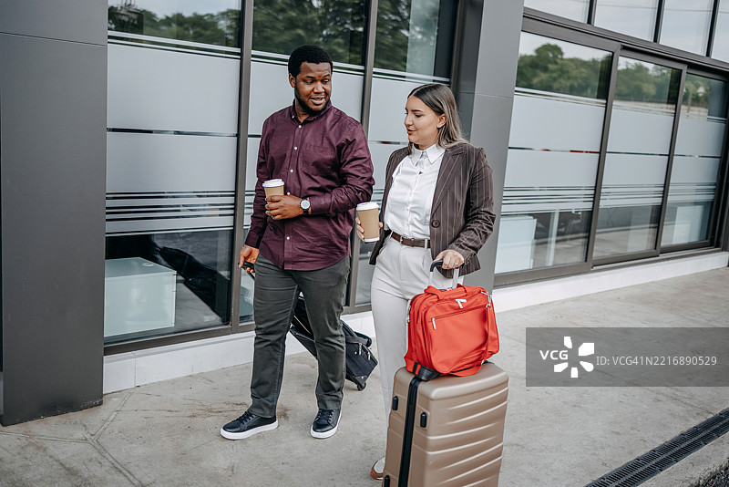 商务人士一起出差，推着行李箱在人行道上行走图片素材
